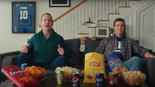 Die beiden ehemaligen Footballspieler Brüder Peyton (l.) und Eli Manning bereiten sich mit Pepsi-Snacks auf den Super Bowl vor.